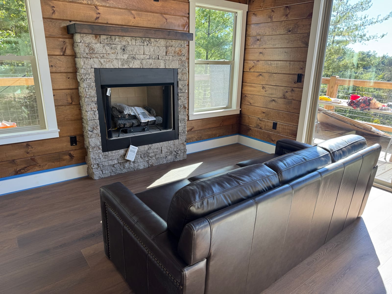 Leather couch facing the stone gas fireplace